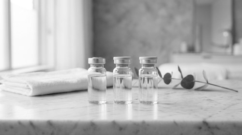 NAD plus and GHK-Cu copper peptide vials on a marble medspa counter, reflecting the standalone wellness peptide protocol prescribed by Dr. Frank Agullo, MD, FACS, double board-certified plastic surgeon at Southwest Plastic Surgery in El Paso, Texas